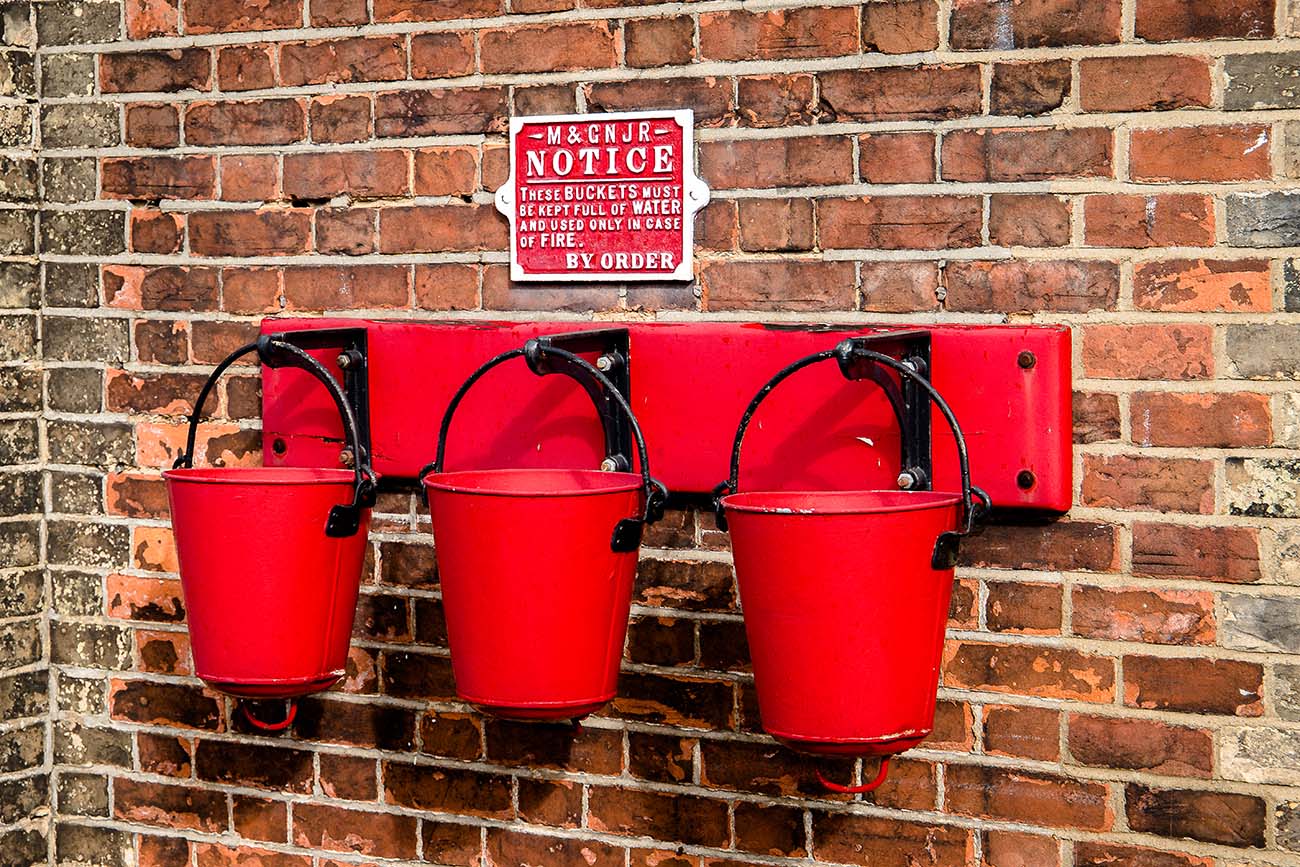 Three fire buckets hanging on the wall